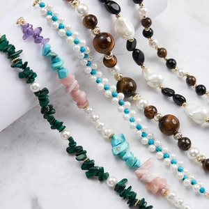 Collection of natural faceted beaded bracelets featuring turquoise and pearls on marble