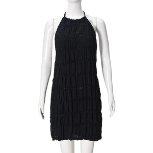 Detail of the black halter mini dress with horizontal pleated texture on a mannequin
