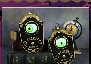 Détail de la sonnette d'Halloween avec œil vert lumineux et texte doré Push to Ring