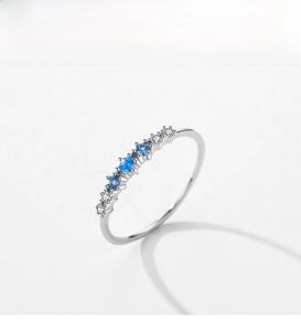 Detail of S925 silver ring featuring alternating sky blue gems and white zircons