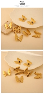 Detailed macro view of golden butterfly earrings featuring natural stones and pearls
