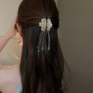 Detail of traditional flower hair stick with pearls and silk tassels on hair