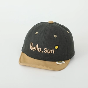 Détail de la broderie hello sun et du bord souple bicolore sur cette casquette bébé