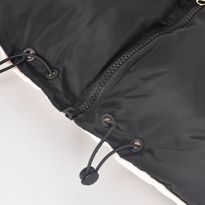 Detailed close-up of a zipper, drawstring toggle, and black nylon windproof fabric
