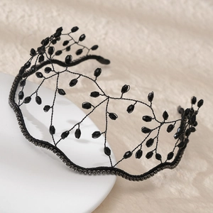 Detailed view of hand-woven black crystal beads and rhinestone crown on a white plate