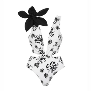 Detail of deep V-neck one-piece swimsuit with 3D floral accent and black floral print