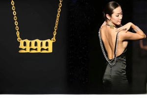 Close-up of golden number 999 pendant with gothic font and model wearing the necklace