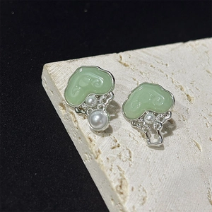 New Chinese style Ruyi brooch with pearls and green agate on a beige stone surface