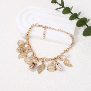 Detailed shot of Baroque pearl bracelet with golden sea shells and natural conch charms