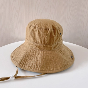 Détail d'un chapeau de soleil extérieur en nylon kaki avec mentonnière réglable et œillets