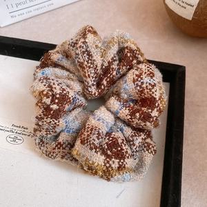 Vue détaillée du chouchou en tweed avec texture de fibres douce sur cartes décoratives