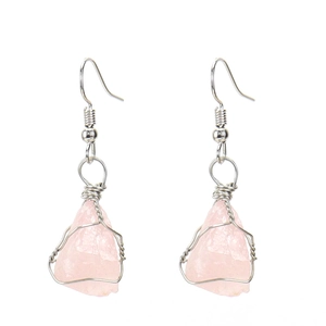 Detail of handmade silver wire wrapped raw pink quartz crystal earrings with silver hooks