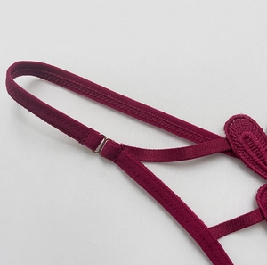 Close-up of wine red lace embroidery and adjustable strap buckles on a sexy thong