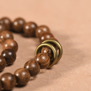 Ebenus double-loop bracelet with brown wooden beads and vintage bronze rings