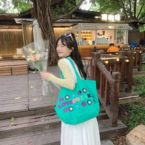 French style floral canvas tote bag with embroidery shown in a casual outdoor lifestyle scene