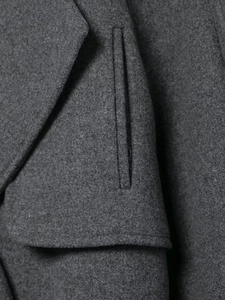 Detail of premium dark grey wool coat showing precision stitching on pockets and lapels