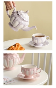 Detail of vintage embossed ceramic tea set with floral texture in pink and purple colors