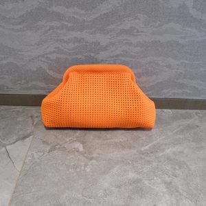 Bright orange woven crochet clutch bag with minimalist cloud-style pleated knit texture