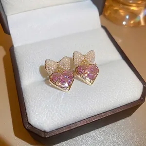 Pink heart zircon earrings with pearl bow detail in gold plated finish for women