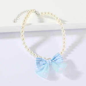 Detail of pearl pet necklace featuring a light blue plaid bow and adjustable metal clasp
