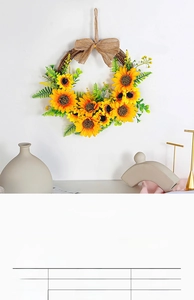 Close-up of artificial sunflower wreath with green leaves and a rustic burlap bow