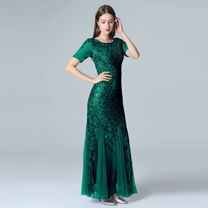 Detail of dark green evening dress with leaf-pattern sequins and soft mesh mermaid hemline