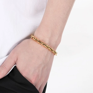 Close-up of a gold titanium steel chain bracelet on a male wrist with a minimalist design
