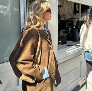 Detailed texture of a brown suede midi jacket paired with a matching shoulder bag
