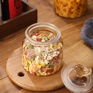 Amber heart-shaped handle glass storage jar with vertical stripes and colorful pasta