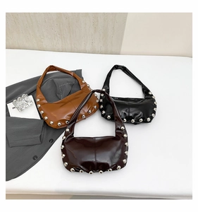 Flat lay of three hobo shoulder bags with silver rivet studs in black brown and burgundy