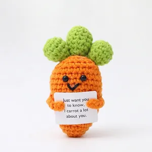 Detailed knit carrot doll holding a card saying I carrot a lot about you with green leaves