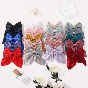 Glossy satin bow hair clips in multiple colors for women and girls on white background