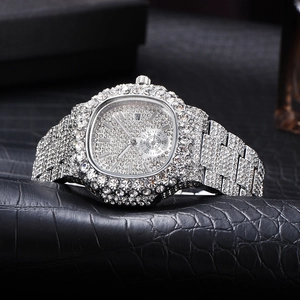 Dettaglio ravvicinato di un orologio di lusso in argento con strass lucidi e calendario