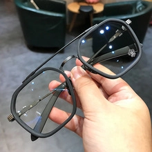 Detail view of rimless square sunglasses featuring silver cross metal accents and double bridge