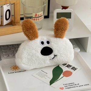 Detail of cute plush cartoon dog pencil case with soft white fur and 3D brown ears