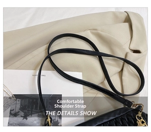 Detail of black quilted shoulder bag featuring golden metal hook and fine stitching