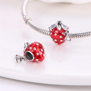 Macro shot of red enamel strawberry charms with sparkling crystals on a silver chain
