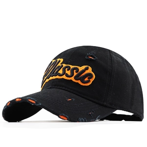 Close-up of black cotton baseball cap featuring orange Classic embroidery and distressed details