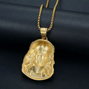 Detail of hip hop gold-plated pendant showing textured relief and square link chain