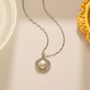Macro detail of square silver necklace with large round pearl and zircon stones
