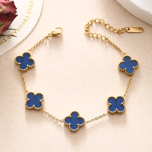 Detailed close-up of golden stainless steel double chain bracelet with blue clover charm