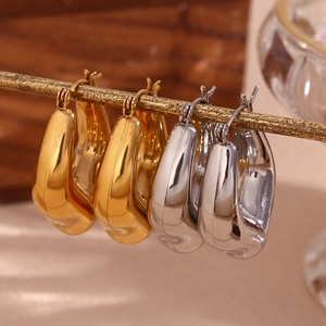 Macro shot of gold and silver teardrop earrings with a hammered polished metal finish