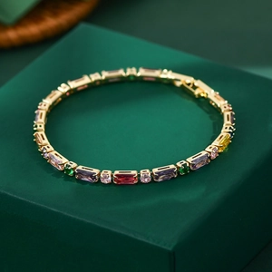 Colorful zircon claw chain bracelet with gold-plated metal on green velvet background
