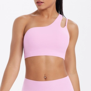 Detail of light pink one-shoulder sports bra showing asymmetric straps and cutout design