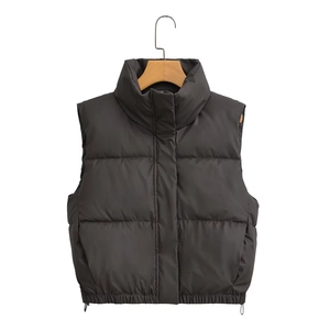 Detail of black quilted puffer vest featuring a stand collar and adjustable drawstring hem