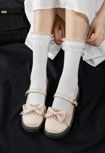 Gros plan sur chaussettes Lolita blanches à dentelle et chaussures Mary Jane à nœuds
