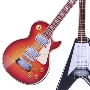 Miniature sunset Les Paul and black Flying V electric guitars for dollhouse scenes