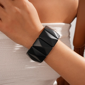 Close-up of a matte black geometric cuff bracelet with a stylish pyramid structure