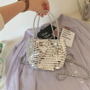 Macro shot of silver sequin shoulder bag with metal chain strap and round handle