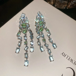 Makroaufnahme von Silber-Quastenohrringen mit hellblauen und mintgrünen Edelsteinen